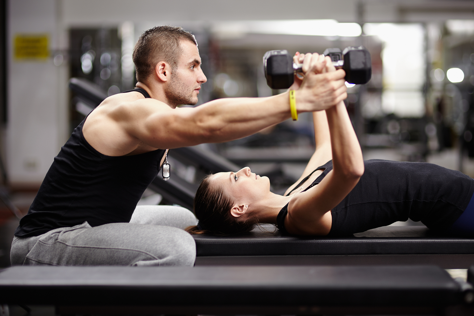 Personal trainer helping woman at gym Personal trainer helping woman at gym
